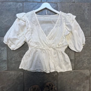 Vit omlottblus med spets från JDY - Säljer denna superfina vita blus från JDY med omlott-design och v-ringning. Använd fåtal gånger! Superfin passform med insydd midja☺️