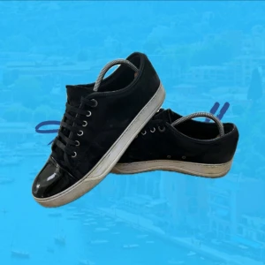 Svarta sneakers från Lanvin med lackdetalj - Snygga svarta sneakers från Lanvin med klassisk siluett. Ovandel i mocka och tåparti i blankt lackskinn, vita sulor och svarta snören. Perfekta för dig som gillar stilrena men ändå unika skor med exklusiv känsla💯😝