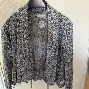 Mönstrad cardigan jacka Odd Molly - Snygg cardigan jacka från Odd Molly i blått och vitt med unikt geometriskt mönster. Jackan har lång ärm, öppen front och är tillverkad i mjukt stickat material. Perfekt för dig som vill ha en cool och bekväm look med lite edge.