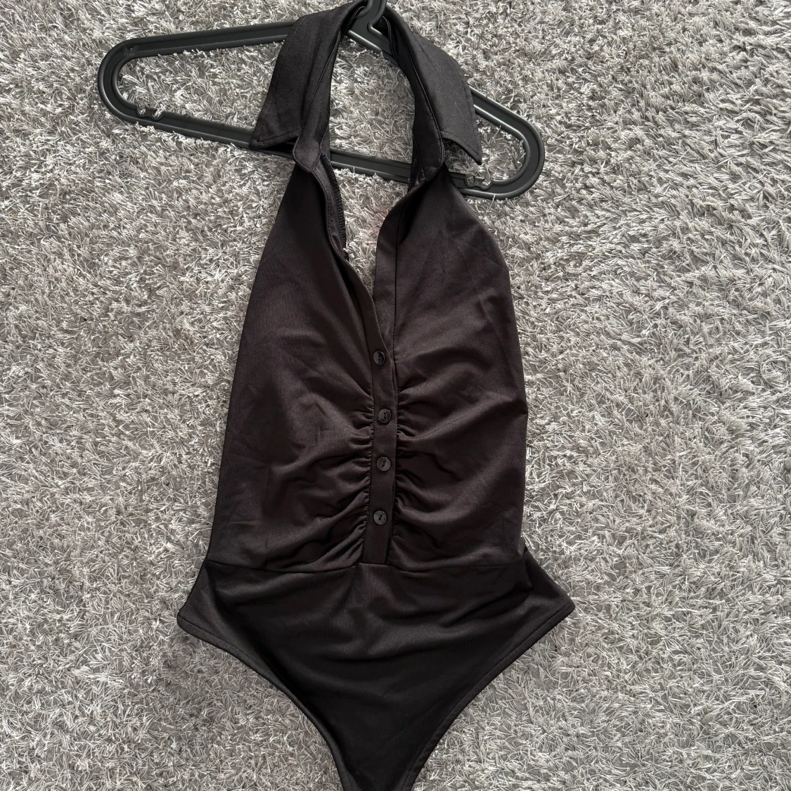 Svart halterneck body med knappar