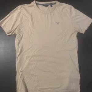 Beige t-shirt från GANT - Snygg beige t-shirt från Gant med broderad logga på bröstet. 