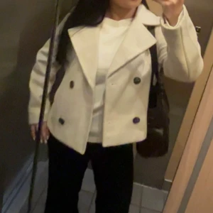 Kort kappa - Snygg beige kappa med knappar från Vero Moda. Perfekt till hösten!! Är lite nopprig men syns inte om man inte kollar jättenoga, annars inga anmärkningar. 