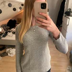 Stickad tröja - En grå stickad tröja som blivit lite kort i armarna. 