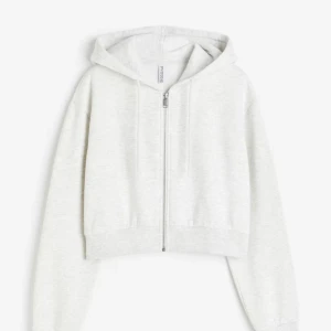 Ljusgrå croppad hoodie från hm  - Superfräsch vit croppad hoodie från hm med dragkedja framtill och huva. Tröjan har långa ärmar, ribbade muddar och är gjord i mjuk bomullsmix. Inga defekter. 