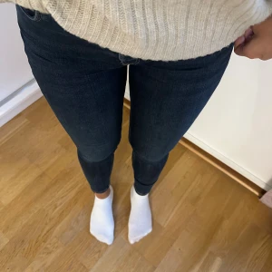 Mörkblå skinny jeans - Säljer ett par mörkblå skinny jeans med klassisk femficksdesign och dragkedja fram. Jeansen har en tight passform och är tillverkade i stretchigt jeansmaterial som sitter snyggt längs benen. Perfekta för dig som gillar en slimmad look.