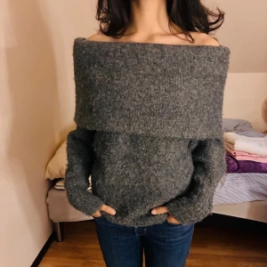 Grå offshoulder stickad tröja H&M - Mysig grå stickad tröja från H&M i offshoulder-modell. Tröjan har en bred krage som vilar över axlarna och långa ärmar. Perfekt för kyliga dagar och enkel att styla med jeans eller kjol. Behöver pengarna och bli av med tröjan så postar redan samma eller nästa dag!❤️