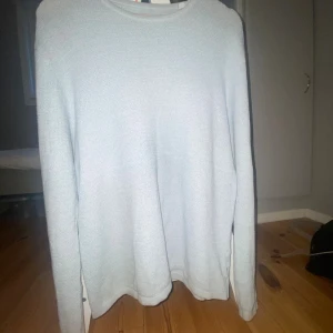 Ljusblå stickad tröja Jack & Jones - En stilren ljusblå stickad tröja från Jack & Jones i storlek S.(passar även M!) Tröjan har rund halsringning och lång ärm, perfekt för lager-på-lager. Mjuk och skön känsla med enkel design som funkar till många outfits.tröjan är i mycket bra skick förutom ett litet hål vid höger armhåla som man då ser på fjärde bilden!