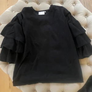 Svart tröja med volangärmar - Säljer en svart tröja med riktigt snygga volangärmar som ger en cool och unik look🩷