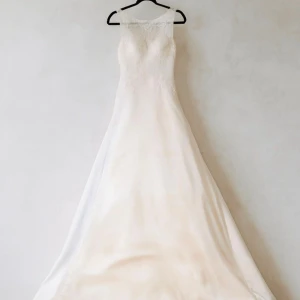 Bröllopsklänning Alicia Eklöw - Exklusiv bröllopsklänning i ivory/off-white från Alicia Eklöw, köpt på Kristina Brud & Fest för 11 000 kr. Storlek M (kan justeras hos sömmerska). Klassisk och elegant design med figurnära överdel, markerad midja, vackert fall, släp och tyll för extra form. Mycket bekväm och lätt att röra sig i hela dagen. Endast använd några timmar på bröllopsdagen, i mycket fint skick. Säljs med originalfodral, sjal och hårkam med slöja.