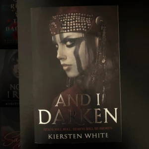 And I Darken - En mörk och fängslande bok med en kraftfull kvinnlig huvudkaraktär. Perfekt för dig som gillar episka berättelser, maktkamp och dramatik. Omslaget utstrålar mystik och styrka, vilket lockar unga vuxna som söker spänning och intensiva känslor.