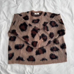 Stickad tröja med leopardmönster  - Stickad tröja från Luzabelle i beige med leopardmönster i brun & svart. Aldrig använd, i storlek S/M. Nypris: 659kr Fraktar inom 24h!