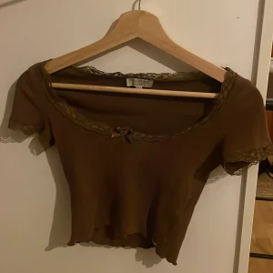 Brun topp med spets från Pull&Bear - Brun spets topp som knappt är använd från Pull&Bear 