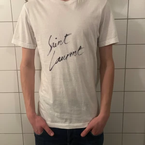 Saint Laurent t shirt  - Riktigt fet och eftertraktad saint Laurent t shirt i storlek S! Helt nytt skick! Lite osäker på äktheten eftersom tag saknas så därför är priset just nu på 499kr nypris runt 3000kr! Tveka inte med att ställa frågor! 