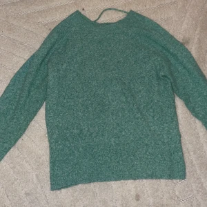 Grön stickad tröja från Vero Moda - Mysig grön stickad tröja från Vero Moda i storlek XXS. Tröjan har en enkel och klassisk design med rund halsringning och långa ärmar. Perfekt för lager-på-lager under kyligare dagar.