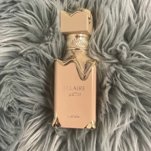 Lattafa Eclaire Parfymflaska - Snygg parfym från Lattafa med namnet Eclaire. Flaskan har en modern design med guldiga detaljer – perfekt för dig som vill sticka ut. Har har sprayat få gånger (3-5 gånger har jag sprayat) helt ny men utan box. köptes för 439kr