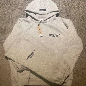 Essentials tracksuit grå - Essentials tracksuit i bra skick taggen är tyvärr inte kvar längre. Har ett litet hål vid armhålen och därför det billiga priset. Storlek S men passar även XS