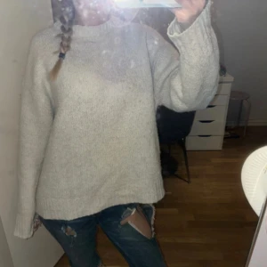 Ljusgrå stickad tröja - Mysig vit stickad tröja med rund hals och långa ärmar. 