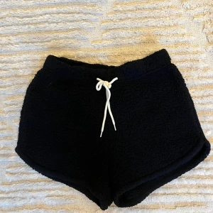 Mjukisshorts från Hollister - Världens skönaste svarta mjukisshorts i fleece med vit snörning i midjan. Dessa är från Hollisters kollektion: Gilly Hicks By Hollister 🌟 Perfekta för en chill dag hemma och framförallt nu till hösten och vintern 🍁Använda ca 1-2 gånger och passar även XS och S
