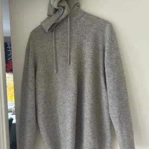 Grå hoodie i kashmir från Vernando - Mjuk och lyxig grå hoodie från Vernando i kashmir. Tröjan har huva med snörning, ribbade muddar och lång ärm. Perfekt för dig som vill ha en stilren och bekväm look med premiumkänsla. Jag är runt 182-183 o den sitter bra. Används fåtal gånger ( runt 5 typ ) vid snabb affär kan jag gå ner i pris.