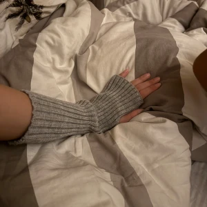 Grå ribbstickade fingerlösa vantar - Säljer ett par gråa, ribbstickade fingerlösa vantar. De är långa och går upp en bit på underarmen, med öppning för tummen. Perfekta för dig som vill hålla händerna varma men ändå kunna använda mobilen eller datorn.