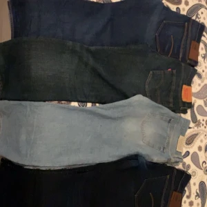 Fyra par Levi's jeans i olika blå nyanser - Fyra par klassiska Levi's jeans i olika blå nyanser, från ljusblå till mörkblå. Alla har femficksdesign och tydliga Levi's-lappar bak i midjan. Perfekta för dig som gillar tidlös denimstil och vill ha flera färgval i garderoben.