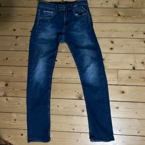 Replay Hyperflex Grover jeans blå - Säljer ett par Replay Hyperflex Grover jeans i klassisk blå tvätt. De är storlek 29 32. Jeansen har raka ben, fem fickor och snygga detaljer vid fickorna. Materialet är stretchigt för extra komfort och passformen är normal. Perfekta för dig som gillar stilrena och bekväma jeans. De har dock ett litet hål vid grenen men borde inte vara så svårt att laga. Perfekta inför hösten!🔥
