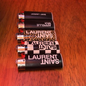 Saint Laurent Paris Limited Edition Tändare - Snyggt set med 5 Saint Laurent Paris tändare i olika designer: svart, rutigt, leopard och med text. Alla i jätte fint skick köpt för 10 minuter sedan säljes för 100 st. Köpare står för frakten