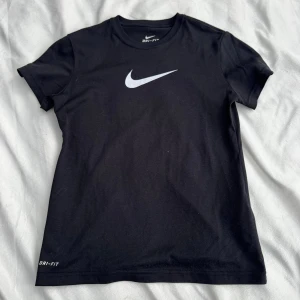 Nike t-shirt - Svart T-shirt från Nike i Dri-Fit-material. I storlek 137/146. Fraktar inom 24h!