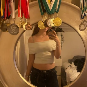 Vit offshoulder  - Använd tre gånger. Säljer en vit offshoulder topp med tight passform. Toppen är ärmlös och materialet är mjukt och stretchigt.