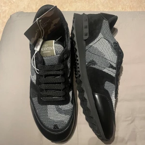 Valentino Garavani Rockrunner sneakers - Fick de i födelsedagspresent men de är tyvärr för små. Har bara testat ena skon eftersom jag ej ville riskera slitage på dem. ALLT på sista bilden fås med. STORLEK: 44-45 SKICK: sprillans nya PRIS: Kom med bud om priset ej passar dig