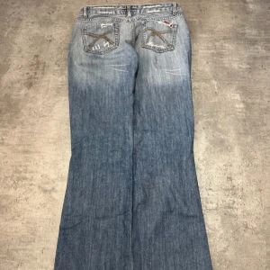  Bootcut jeans med slitningar - Snygga ljusblå jeans med breda ben och slitna detaljer framtill. Längd: 101cm - Midja: 39cm innerbenslängd: ca 78cm  Pris kan diskuteras🥰