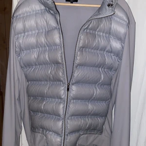 Grå pufferjacka från ARNE Active - Snygg grå pufferjacka från ARNE Active i storlek L. Jackan har quiltad framsida med dragkedja och släta ärmar. Perfekt för dig som gillar stilren och sportig look. Lätt och bekväm att bära, passar till många outfits. Ord pris 1200kr