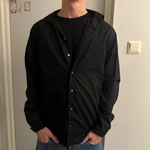 Svart skjorta  - Stilren skjorta i slim fit från The shirt Factory i storlek 38. Bra skick! Killen på bilden är 180,65 kg! Må bäst! 