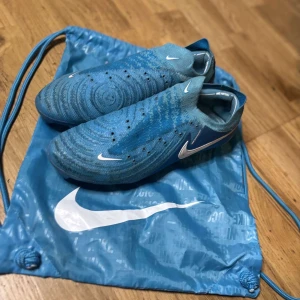 Nike Phantom GT blå fotbollsskor - Säljer mina Nike Phantom GX Elite fotbollsskor, använda men i bra skick. Storlek 42/5. Perfekta för spelaren som söker precision och komfort. Använda på konstgräs. Kvitto finns !FINNS SKOSNÖREN!