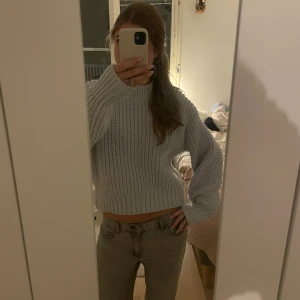 Ljusblå stickad tröja! - Säljer en ljusblå stickad tröja med grov ribbad struktur och rund hals. Tröjan har långa ärmar och en loose passform som ger en chill vibe. Perfekt att matcha med jeans eller kjol för en snygg look.