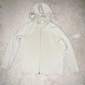 Beige hoodie med dragkedja från Samsøe Samsøe - Säljer en stilren off white färg hoodie från Samsøe Samsøe, modell Saniklas 15333. Materialet är mjukt och känns skönt. Passformen är normal. Storlek S passar även M. Väldigt ny