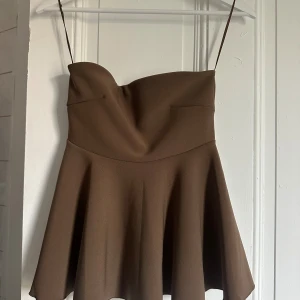 Brun axelbandslös topp - Supersnygg brun topp med axelbandslös design . Storlek M