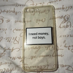 iPhone 7/8 Genomskinligt Skal - Genomskinligt mobilskal för iPhone 7/8 med unik sticker: 'I need money, not boys.' Skalet visar visst slitage och gulnad men är helt och skyddar din telefon effektivt. Perfekt för dig som vill ha ett personligt och skyddande skal.