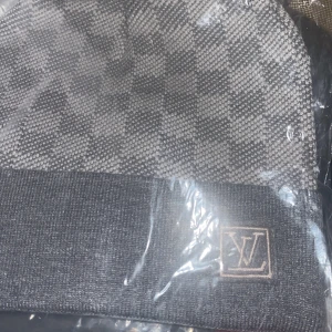  rutig grå mössa - Snygg grå mössa från  med klassiskt rutigt mönster och framtill. Mjuk och varm, perfekt för kyliga dagar. Stilren design som lyfter din look.