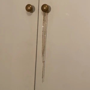 Guldigt lager-på-lager halsband - Säljer ett trendigt guldigt halsband med lager-på-lager känsla. Kedjan har en snygg Y-form och tunna länkar som ger ett stilrent och elegant intryck. Perfekt för att lyfta vilken outfit som helst med lite extra bling.