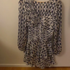 Blommig kortklänning från Zara - Säljer en kort klänning från Zara med blått och vitt blommigt mönster. 