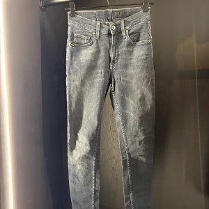 Blå slim jeans från T/J - Snygga blå skinny jeans från T/J med klassisk femficksdesign och ljus tvätt. Jeansen har en hög midja och smal passform som sitter tight längs benen. Materialet är mjukt jeans och bakfickorna har stilrena sömmar. Perfekt för dig som gillar en modern look.
