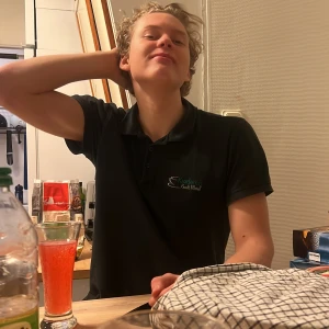 Andre  - Säljer en svart pikétröja med korta ärmar och krage från Ekodalen Krog & Motel. Tröjan har broderad logga på bröstet och klassisk pikéknäppning framtill. Perfekt för dig som gillar enkel och stilren look.