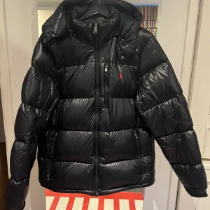 Ralph Lauren The Gorham Down Jacket – Svart – Fint Skick - Säljer min Ralph Lauren The Gorham dunjacka i färgen svart. Jackan är i mycket fint skick, knappt använd och utan fläckar eller skador. Nypris ca 5 500 kr. Varm, stilren och perfekt för vintern.  📏 Storlek: M 💰 Pris: 3 800 kr (eller bud) 📍 Finns i Stockholm – kan skickas om köparen betalar frakten.