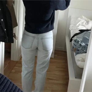 Ljusblå raka jeans - Säljer ett par ljusblå jeans med raka ben och klassisk femficksdesign. Jeansen har hög midja och är tillverkade i mjukt denimtyg. Perfekta för en chill och stilren look.