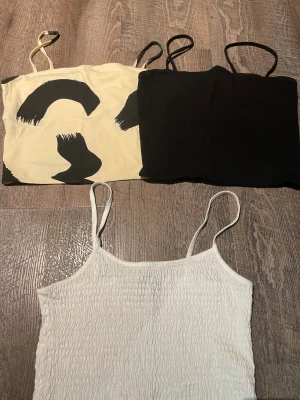 Tre bandeau toppar med smala axelband - vitt linne från bikbok i st s, använd 1 gång.  Svarta och beiga linnet är från monkey o st S och köptes tillsammans. 25kr st eller 60kr för alla .