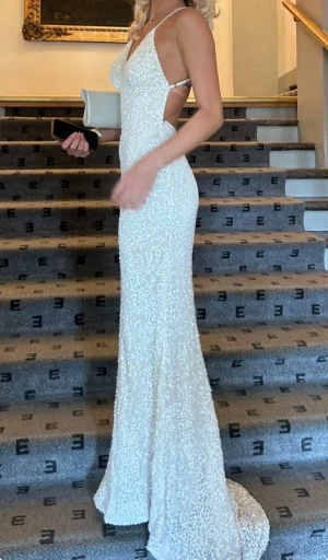 Vit balklänning - Vit paljett balklänning från dressroom linne’ i storlek 0 vilket motsvarar 32/xxs🤍Nypriset ligger runt 5000kr, det har lossnat några paljetter under bröstet som syns på sjette bilden men inget som är tydligt när den används! Den är upsydd till mig som är 167 men går också att sprätta upp😊