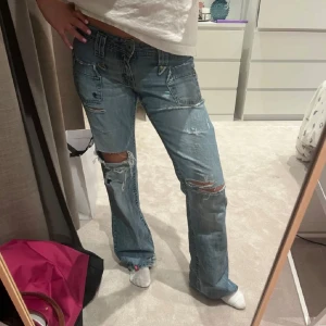 Lågmidjade jeans  - Midjemått: 41 cm Innerbenslängd: 78 cm💕Säljer nu dem snyggaste lågmidjade bootcut jeansen, dem är håliga!💕det är ett ganska stort hål bak i rumpan men det är nog inte så svårt att du ihop men orkar själv bara inte (se bild 2). Har redan försökt sy dem men de har dessvärre gått upp igen men inte svårt att lösa💕skulle uppskatta dem till storlek 36/s. Är 164 och lite långa på mig 💘lite uppsprättat nere vid fötterna men inget man tänker på💕 hör av er vid frågor eller intresse 🥰