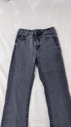 utsvängda gråa jeans- flare - Snygga grå jeans från Denim 1953 i utsvängd modell. Klassisk femficksdesign, dragkedja och knapp framtill. Jeansen är tillverkade i ett mjukt denimtyg och har en stilren look som passar till det mesta. Modellen heter Susan.