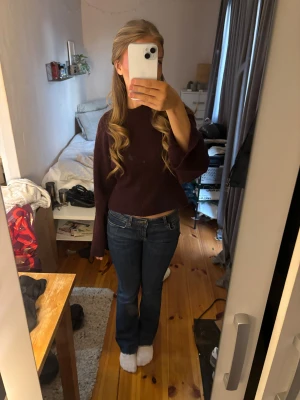 Blå bootcut jeans låg midja - Säljer ett par snygga blå jeans med bootcut och låg midja. Jeansen har klassisk femficksdesign och är tillverkade i ett stretchigt denimtyg som sitter skönt. Passformen är normal och benen är lätt utsvängda nedtill för en cool siluett.